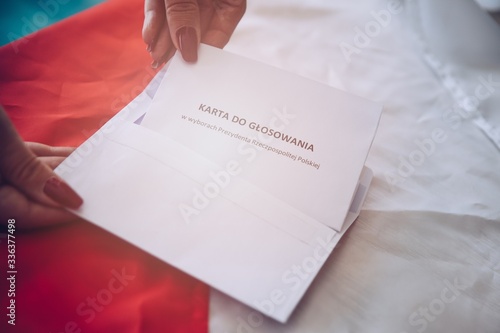 Woman putting correspondence postal ballot paper to envelope. photo