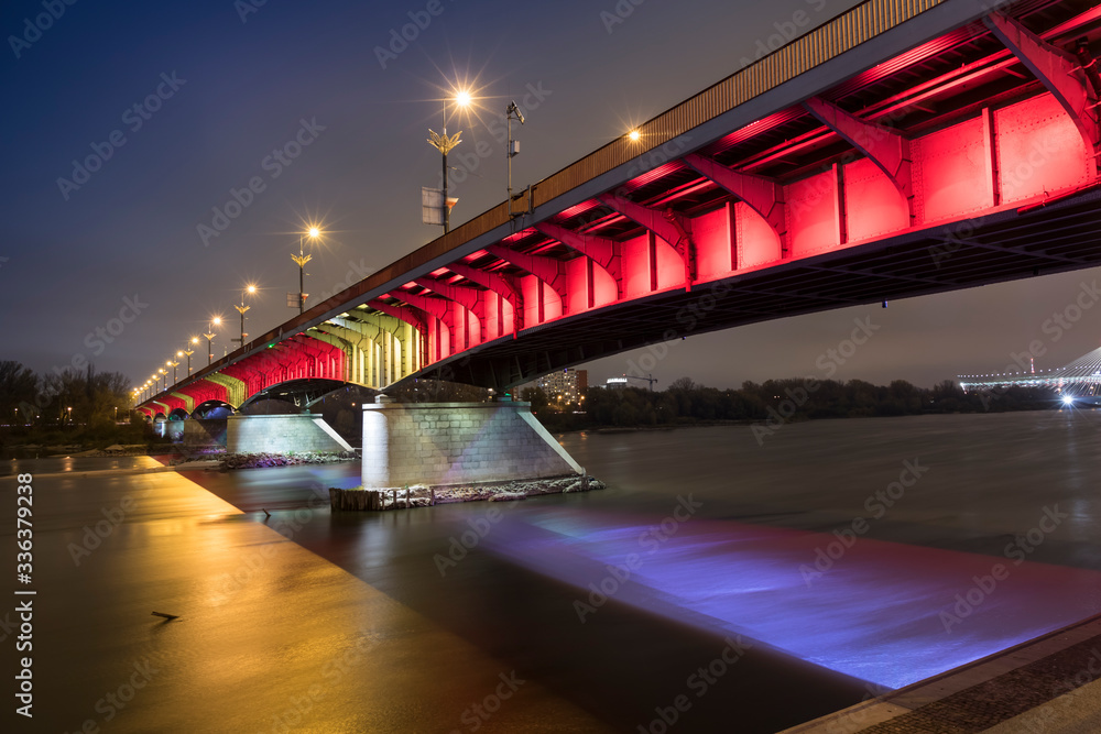 Modern illuminated bridge in Warsaw - capital of Poland. Boulevards on the Vistula river.