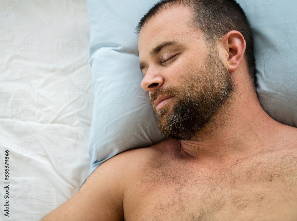 Obraz premium Man sleeping in bed at home