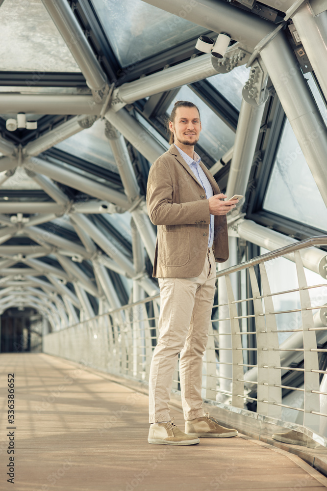 young businessman smiling at the message in your phone young businessman smiling at the message in your phone