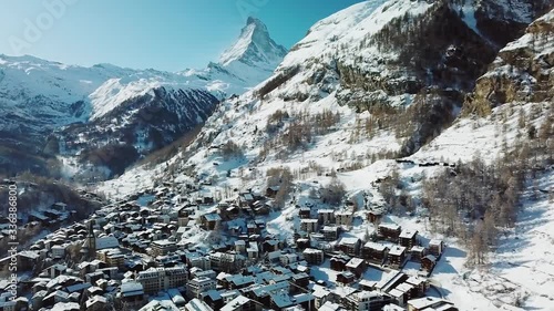 Aerial, pan, drone shot over the Zermatt village, Matterhorn in the background, on a sunny, winter day, in Valais, Switzerland photo