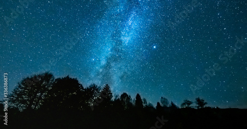 Starry night above the forest showing the milky way photo