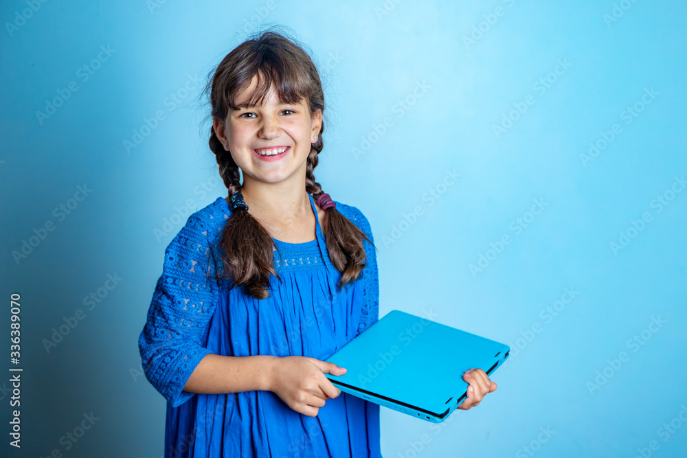 Obraz premium indoor portrait of young child girl with laptop, isolated studio shot, online education