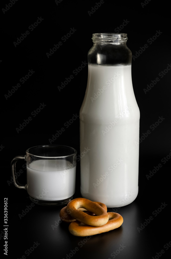 Bottle of milk, cup and bagels on a black background Bottle of milk, cup and bagels on a black background