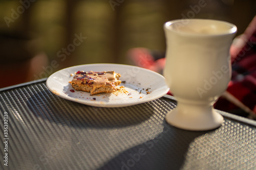 Peice of half eaten toast on an outdoor table on a sunny day