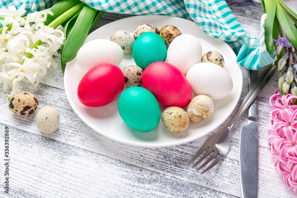 Fototapeta premium Easter eggs in white plate on wooden background. Easter concept