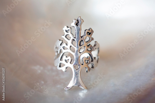 Metal silver color ring in the shape of tree on neutral background