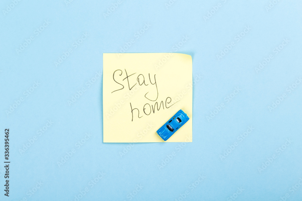 Concept of self-isolation and quarantine. Stay at home. WToy car and sticker with text on blue background Concept of self-isolation and quarantine. Stay at home. WToy car and sticker with text on blue background