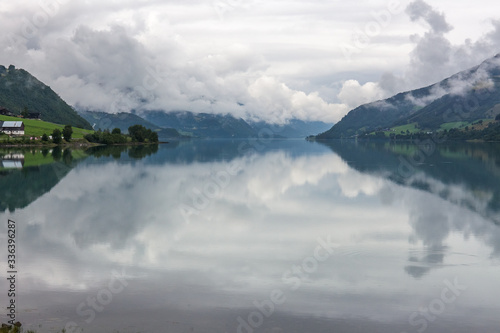 A mystical fjord in Norway with mountains and fog hanging over the water in a beautiful monochrome blue color. selective focus