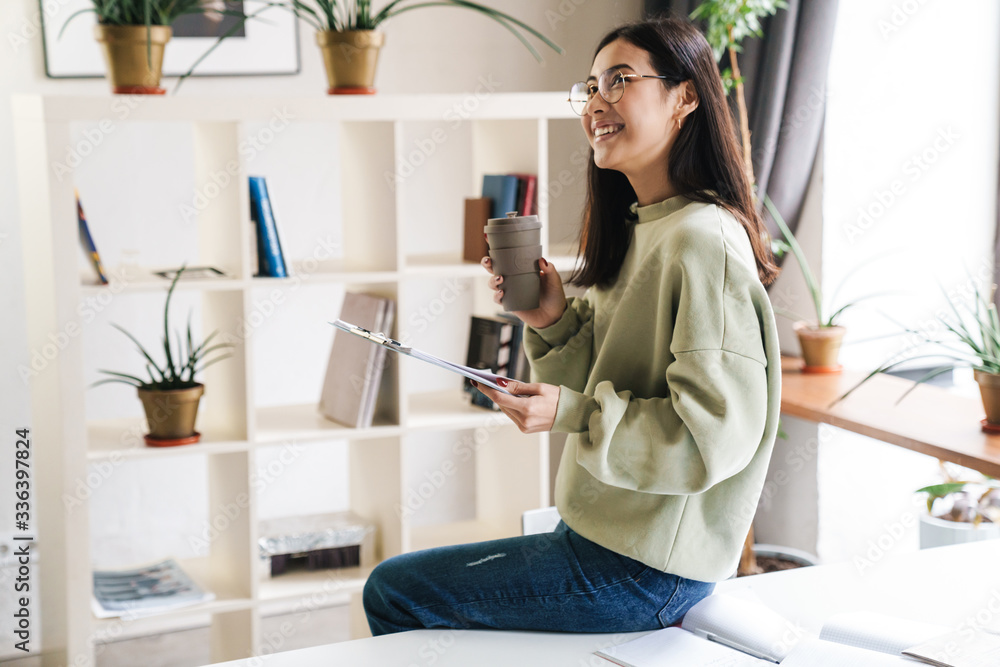 Optimistic young girl student indoors studying Optimistic young girl student indoors studying