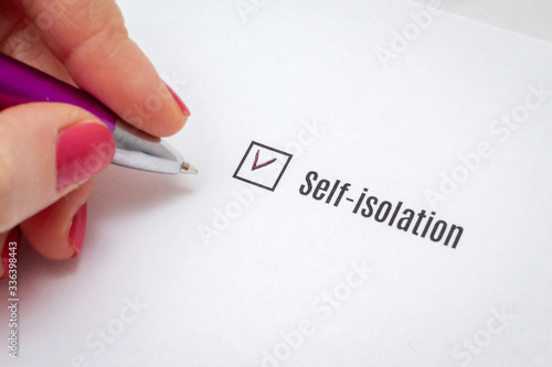 The choice of self-isolation in the check sheet. Hands of a girl fill out a questionnaire.