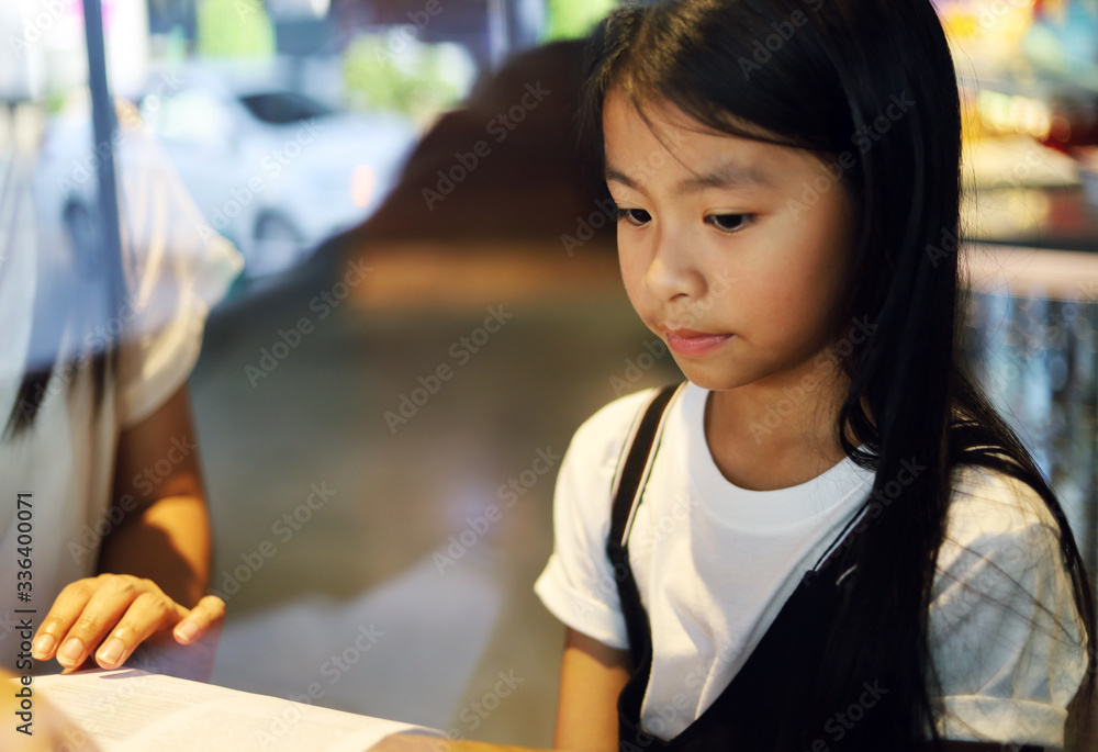 Beautiful kid girl writing homework in summer holiday at coffee cafe. Beautiful kid girl writing homework in summer holiday at coffee cafe.