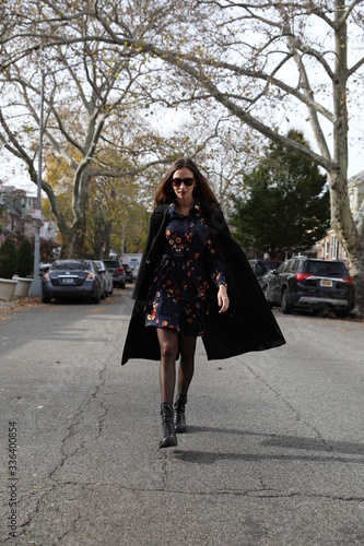 A female model in a dress walks down a street in Brooklyn © olesyabasova