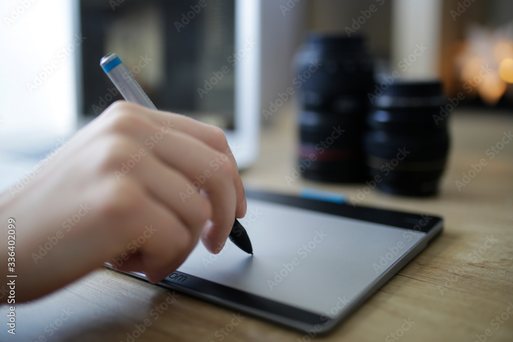 Graphic designer working on digital tablet. Camera on desk in background. Photographer working at office. Photo retoucher work place in modern photostudio. Graphic designer working on digital tablet. Camera on desk in background. Photographer working at office. Photo retoucher work place in modern photostudio.