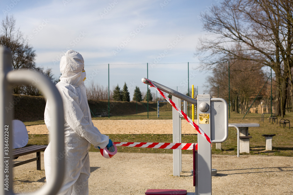 Naklejka premium Kobieta w kombinezonie ochronnym okleja sprzęt sportowy taśmą bezpieczeństwa 