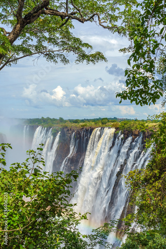 Panorama view with dramatic waterfall Rainbow and clouds at Victoria Falls  Zimbabwe  Zambia. Vertical.