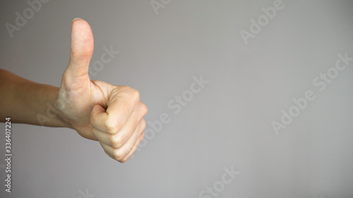 Thumb up of a left female hand. Negative space. Copy space for advertising.