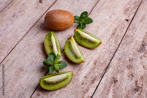 fresh Kiwi and kiwi slices with mint on a wooden background

