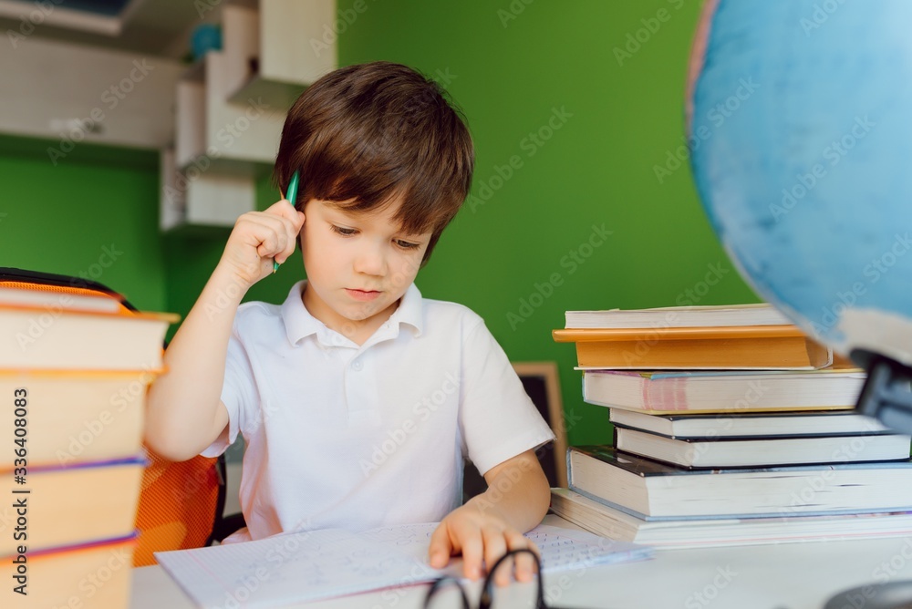 Boy studying at home and doing school homework. Distance learning online education. Boy studying at home and doing school homework. Distance learning online education.