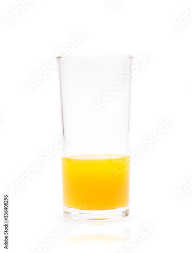 Closeup glass of fresh orange juice less than half isolated on white background with clipping path
