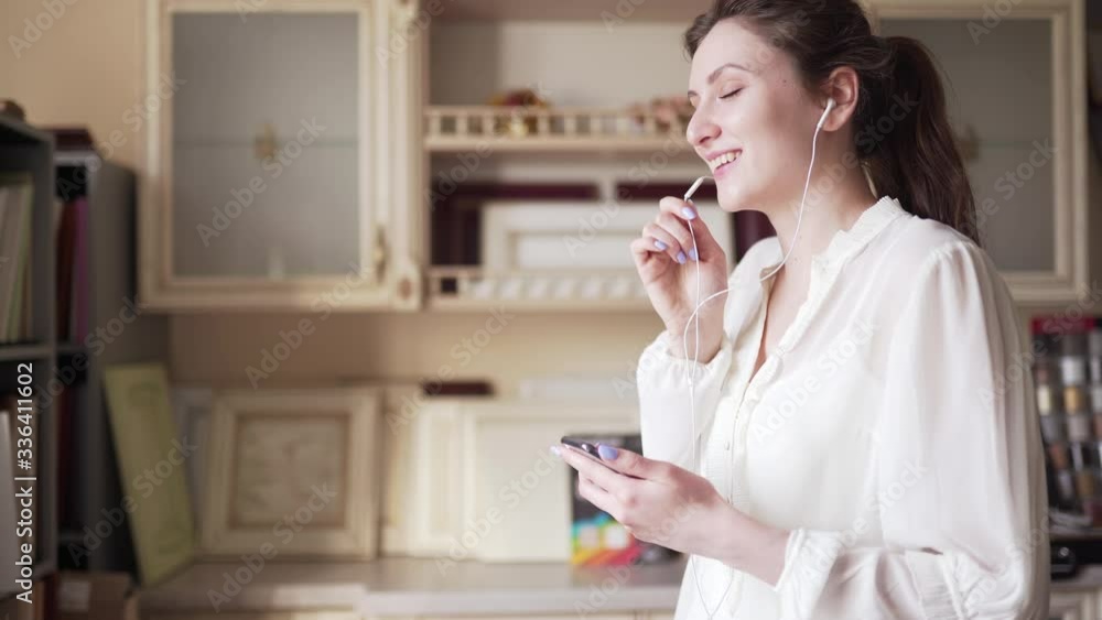 The happy seller talks on the phone talking through headphones and sells the goods remotely. Businesswoman professionally advises the buyer by phone The happy seller talks on the phone talking through headphones and sells the goods remotely. Businesswoman professionally advises the buyer by phone