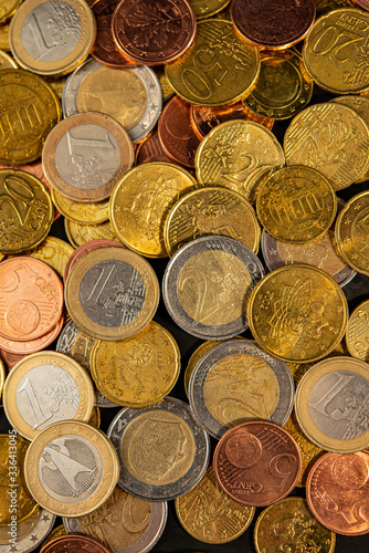 Many euro cents with coins of one and two euros lie.