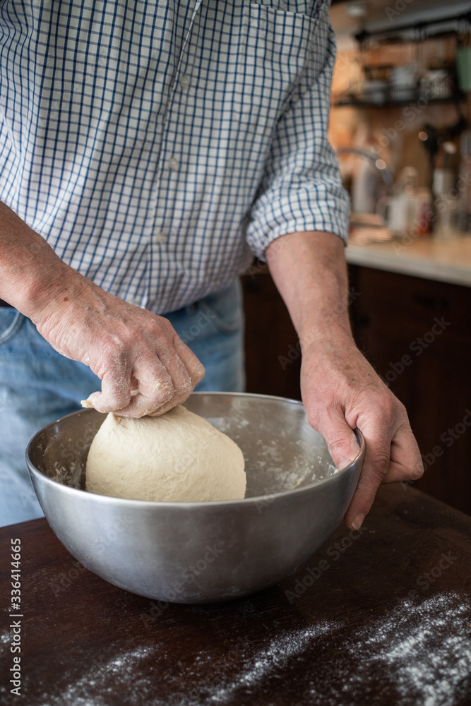 Fototapeta premium male hands making bread in kitchen at home