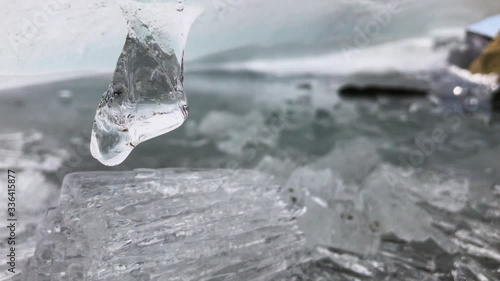 The ice that melts in the spring on the river drips and is sprinkled with sharp parts