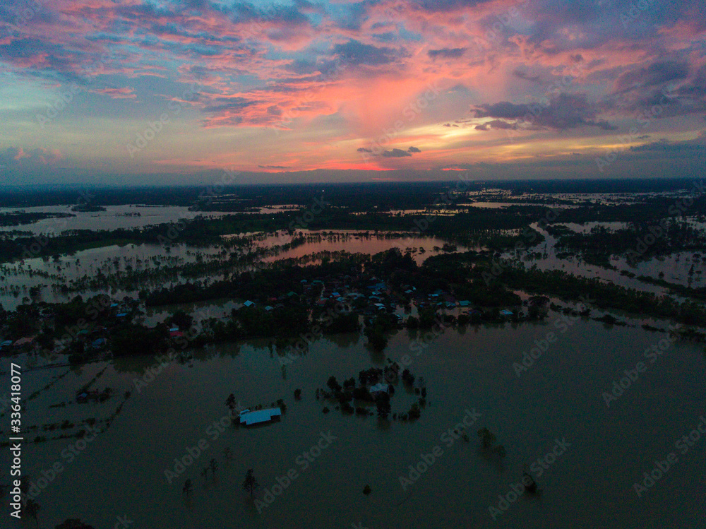 Sakonnakhon, Thailand - August 3, 2017 (Ban kang tha lap village,Kusumal district,Sakonnakhon) : Flood waters overtake a house and rice field in northeast of Thailand from above view by drone