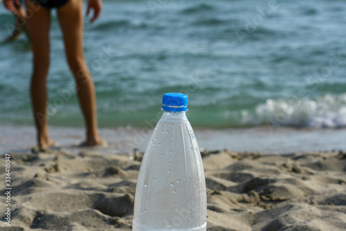 Bottle of water on sandy beach