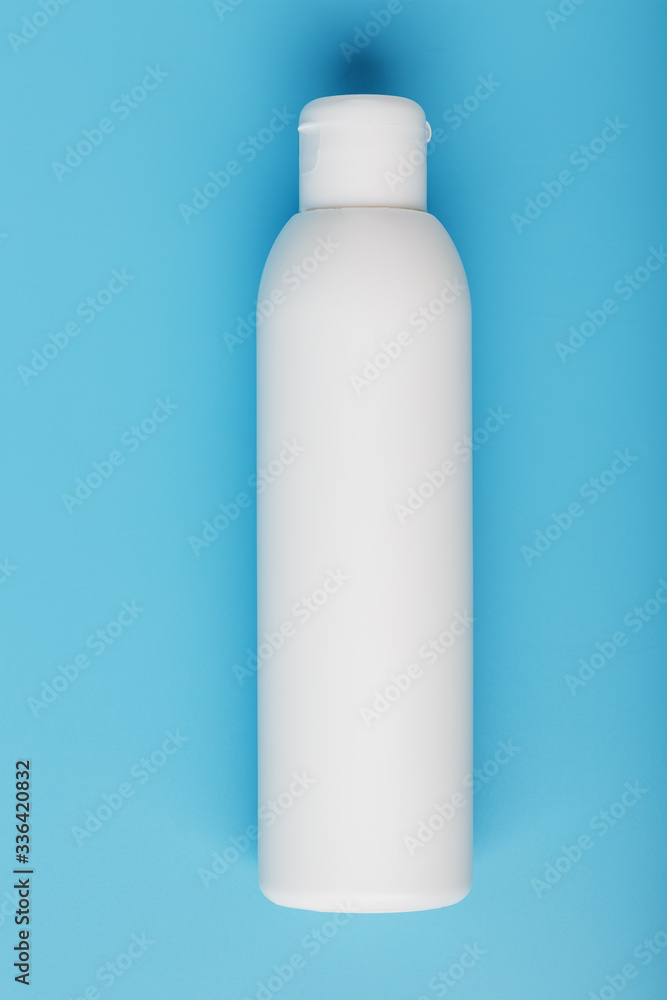 White bottle on a blue background. Free space for text. White bottle on a blue background. Free space for text.