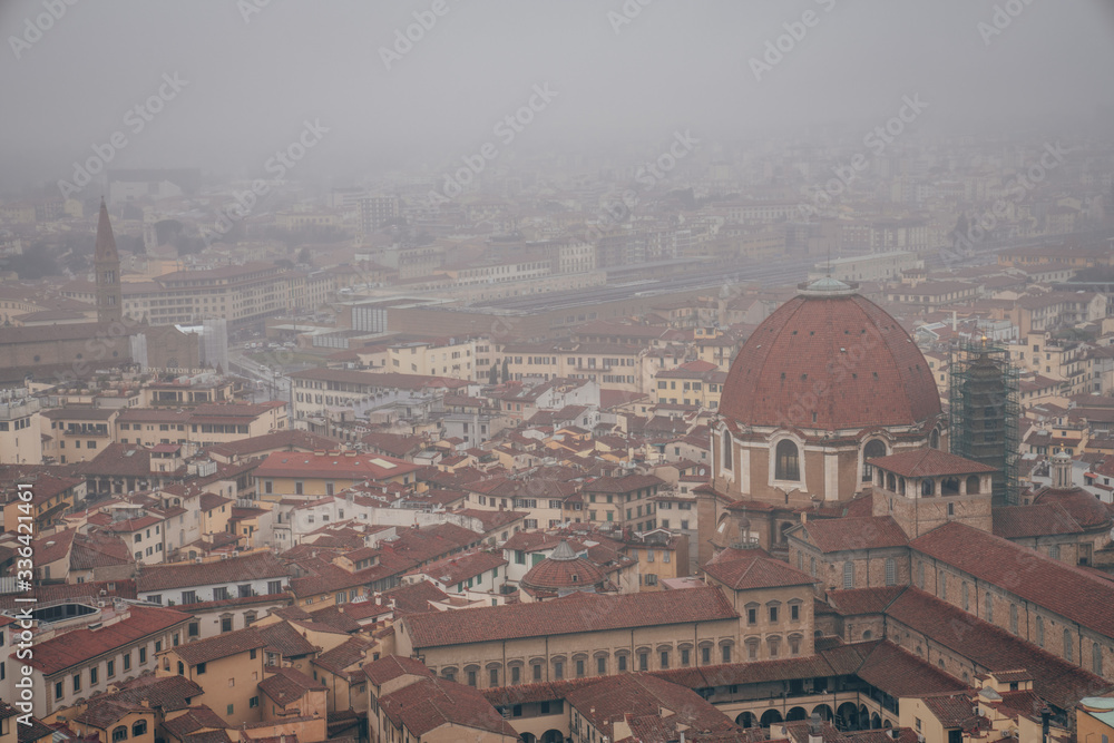 Obraz premium view of the Medici Chapels, the cloister of the Basilica of San Lorenzo and the Santa Maria Novella railway station from the dome of the Florence Cathedral on a foggy day