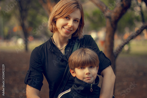 Mother and son posing in the park.