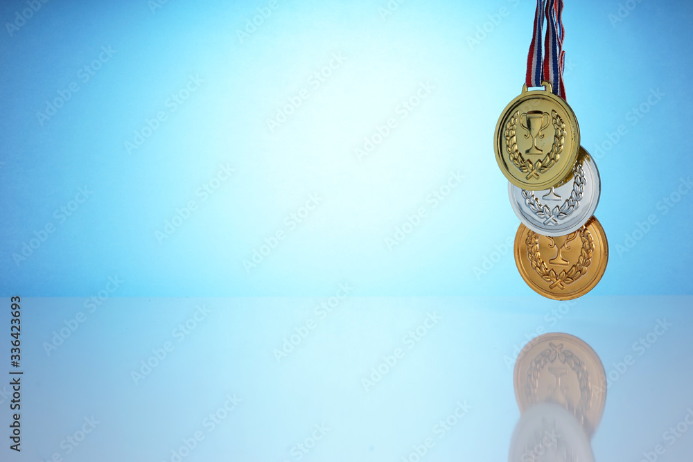 The gold, silver and bronze medal is a symbol of reward in every competition. The champion holds a colections of medal in his hand. The gold, silver and bronze medal is a symbol of reward in every competition. The champion holds a colections of medal in his hand.