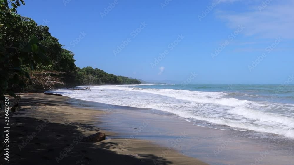 The beach of Punta Uva, Costa Rica, on the Caribbean coast, in a day of strong sea after bad weather. Big waves with sea foam, dangerous to enter. Sunny day. The beach of Punta Uva, Costa Rica, on the Caribbean coast, in a day of strong sea after bad weather. Big waves with sea foam, dangerous to enter. Sunny day.
