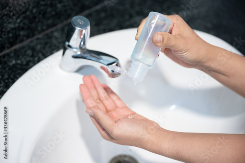 Close up of hands washing by sanitizer gel pump bottle, alcohol gel for prevention coronavirus disesse 2019 (COVID-19), bacteria and germ, health care concept (select focus)