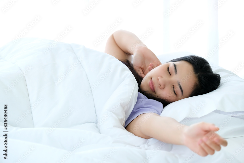 Young beautiful Asia woman wake up and enjoy on the soft bed at the modern bedroom and feeling relaxing in the morning. Hugging soft white pillow. Resting, good dream and sleep concept. Young beautiful Asia woman wake up and enjoy on the soft bed at the modern bedroom and feeling relaxing in the morning. Hugging soft white pillow. Resting, good dream and sleep concept.