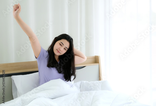 Wallpaper Mural Young beautiful Asia woman wake up and feeling relaxing in the morning with copy space. Raised her arm up to relax. Feeling fresh and ready. Resting, good dream and sleep concept. Torontodigital.ca