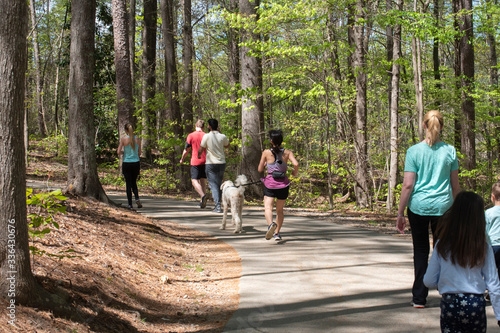 Visitors to Lake Johnson walk and jog along trails while practicing social distancing among the COVID-19 epidemic.