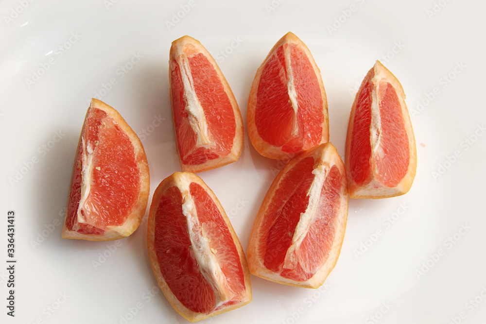 juicy slices of red grapefruit close up on a white background juicy slices of red grapefruit close up on a white background