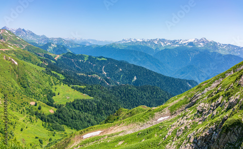 View over the Green Valley, surrounded by high mountains with snow on a clear summer day. © Dmitrii Potashkin