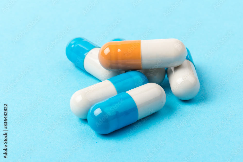 Pills isolated on blue background.Colorful medical drug capsule. Pills isolated on blue background.Colorful medical drug capsule.