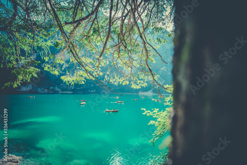 rowboats on the mountain lake seen through the trees in the forest