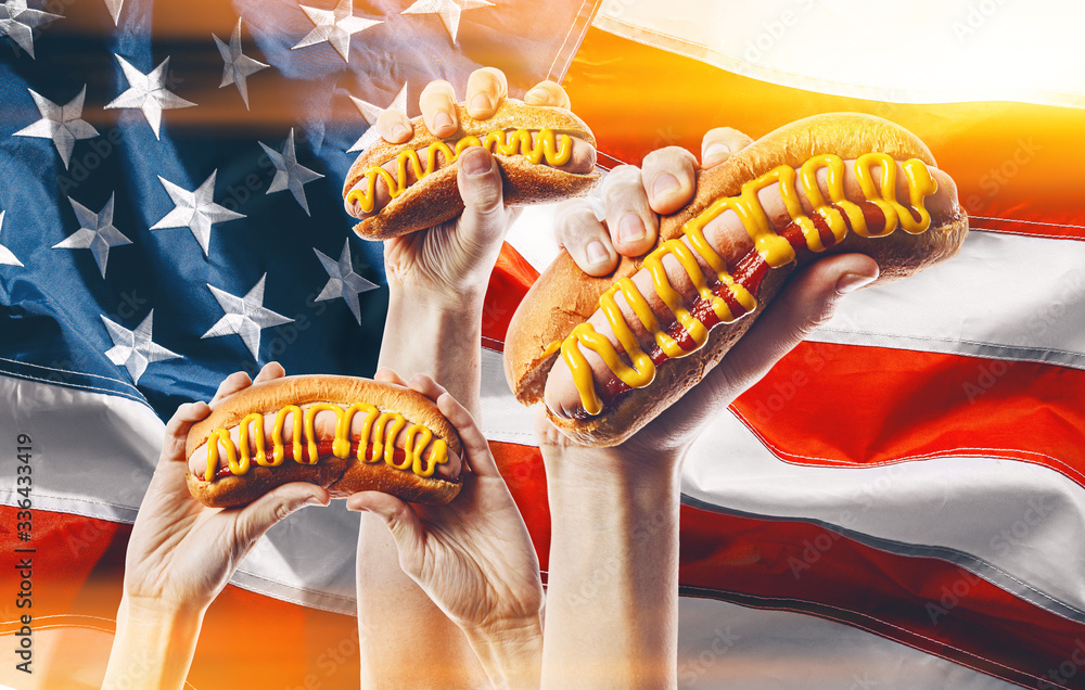 classic american hot dog in hand on american flag background