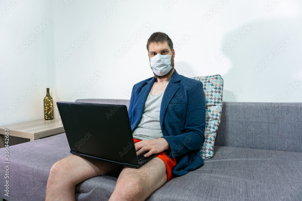 man wear protective medical mask and suit study online with video call. guy watch laptop at home. Covid-19 coronavirus. man wear protective medical mask and suit study online with video call. guy watch laptop at home. Covid-19 coronavirus.