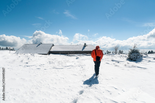 Man heads to a mountain house on a snowy mountain