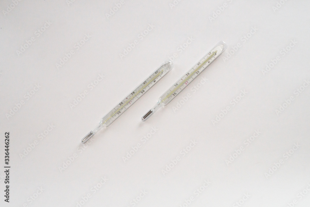 Two analog mercury thermometers on a white background Two analog mercury thermometers on a white background