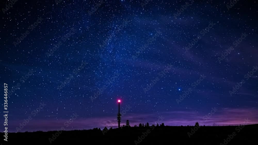 Timelapse of starry night sky in Feldberg, Germany. Illuminated Feldbergturm