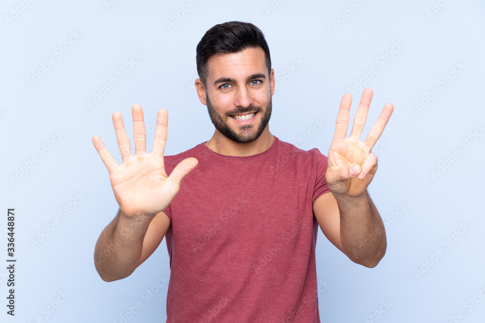 Young handsome man with beard over isolated blue background counting eight with fingers Young handsome man with beard over isolated blue background counting eight with fingers