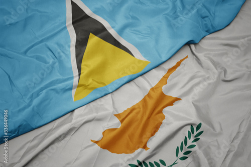 waving colorful flag of cyprus and national flag of saint lucia.